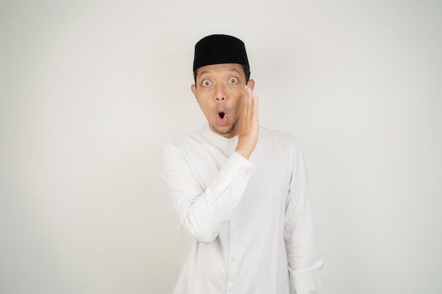 Hombre musulmán asiático contando secretos en la boca susurrando chismes con traje árabe en el espacio de copia