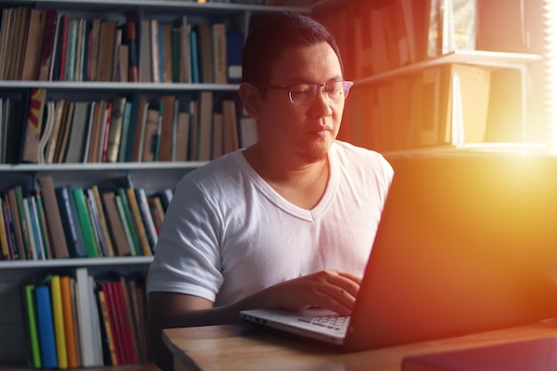 Hombre musulmán asiático estudiando en la biblioteca concepto de preparación para el examen Estudiante universitario que hace investigación
