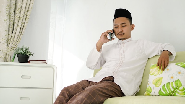 Hombre musulmán asiático sentado en el teléfono