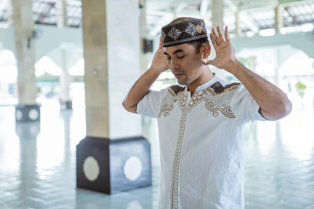 Hombre musulmán asiático takbir solat en la mezquita