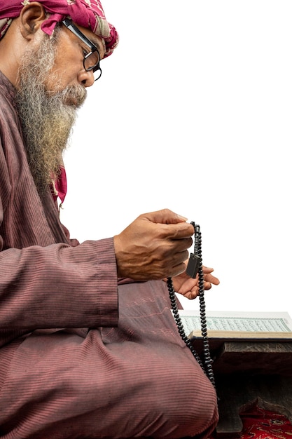 Hombre musulmán con barba usando keffiyeh con agal rezando con cuentas de oración en sus manos