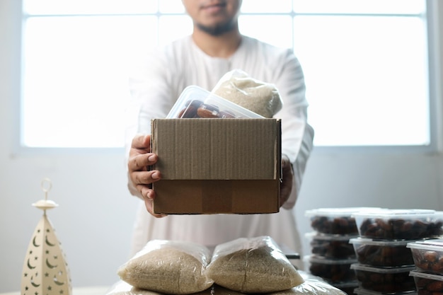 Hombre musulmán donando un paquete de alimentos para la caridad islámica en el mes de Ramadán