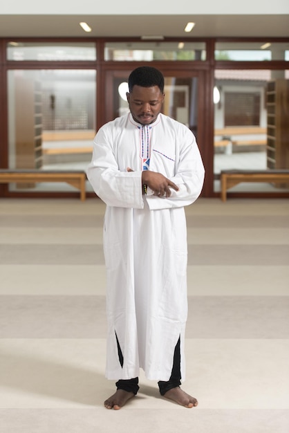 Hombre musulmán está rezando en la mezquita