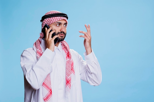 Hombre musulmán hablando por teléfono inteligente