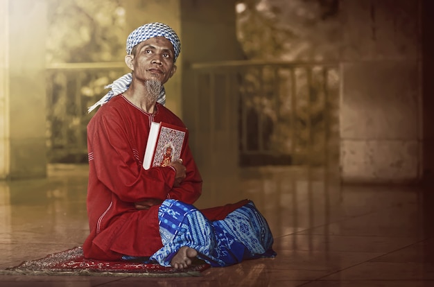 Hombre musulmán religioso leyendo santo koran