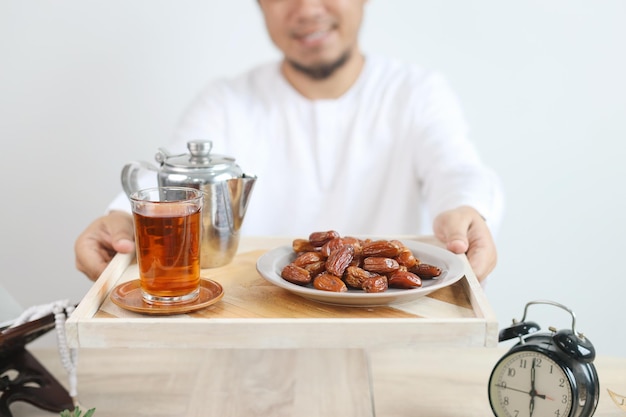 Hombre musulmán sonriente dando comida y bebidas Iftar para el desayuno en el mes de Ramadán