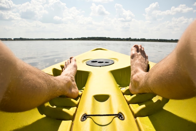 El hombre nada en un kayak en el lago