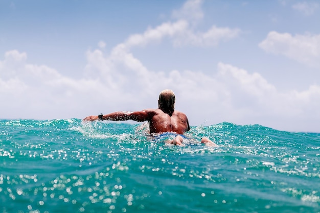 Hombre nadando en el mar contra el cielo