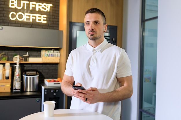 Un hombre navega por Internet desde su teléfono durante una pausa para el café