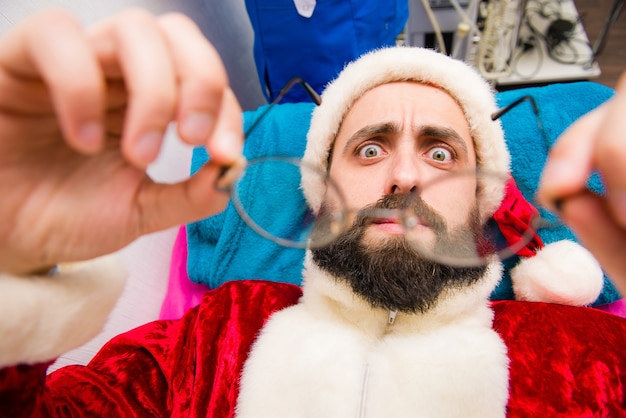 Foto hombre de navidad en ropa de santa claus en el spa de belleza.