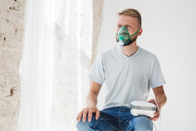 Foto hombre con nebulizador de asma