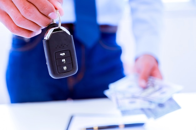 Hombre de negocios acertado que ofrece una llave del coche.