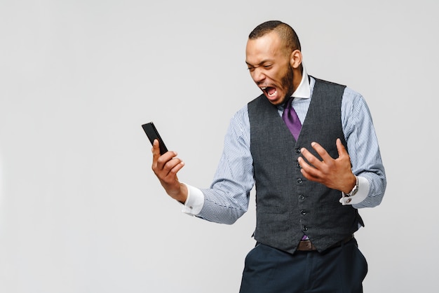 Hombre de negocios afroamericano hablando por teléfono móvil - estrés y negatividad.