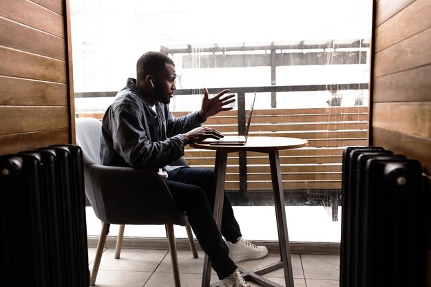 Foto un hombre de negocios afroamericano pensativo que mira la pantalla de una computadora portátil lleva una confirmación de video con