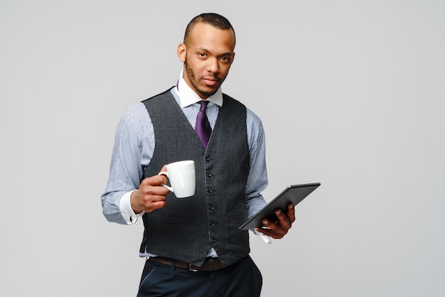 Hombre de negocios afroamericano profesional con tablet pc y taza de café.