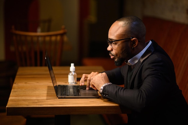 Un hombre de negocios afroamericano en un traje de negocios está hablando en una videoconferencia de videoconferencia ...
