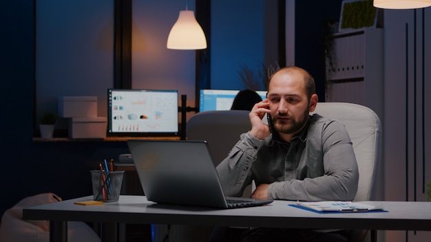 Hombre de negocios agotado sentado en la mesa de escritorio discutiendo ideas de gestión