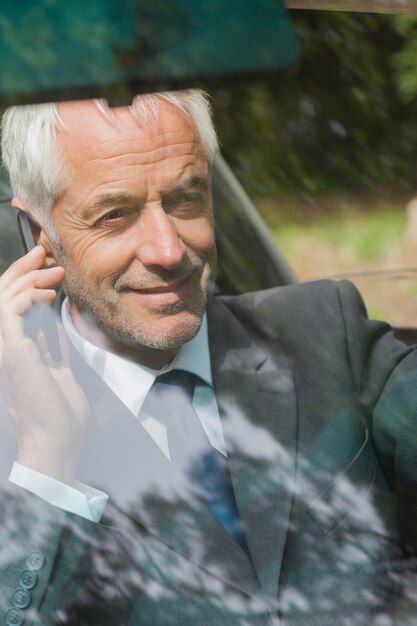 Hombre de negocios alegre en la conducción del teléfono