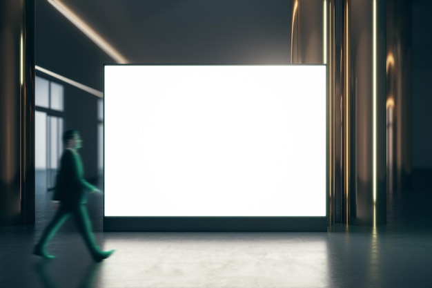 Hombre de negocios ambulante por una pantalla grande iluminada en blanco con lugar para su logotipo o texto entre pilares dorados con piso brillante en la maqueta de fondo de la habitación vacía oscura