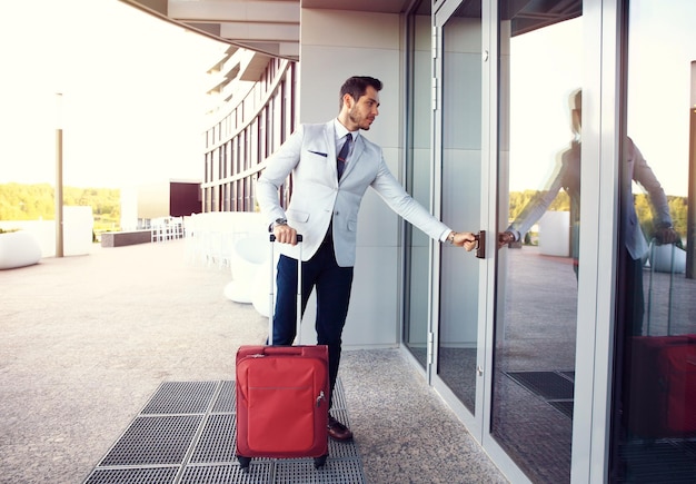 hombre de negocios, ambulante, a, vestíbulo del hotel, retrato largo, de, joven, ejecutivo, con, un, maleta