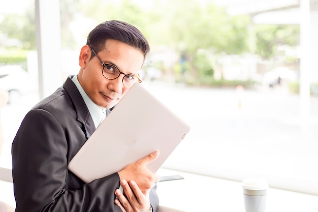 Hombre de negocios de Asia trabajando con ordenador portátil mientras está sentado cafetería