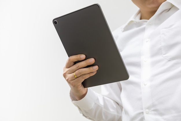 Hombre de negocios asiático con camisa blanca con una tableta de computadora sobre fondo blanco con espacio de copia.