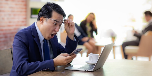 El hombre de negocios asiático celebra en café