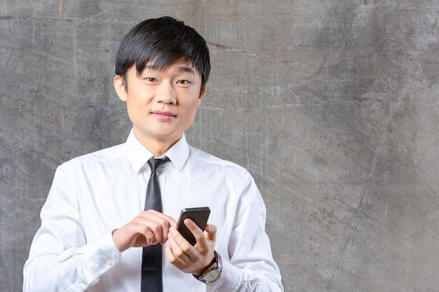 Hombre de negocios asiático hablando por teléfono celular móvil