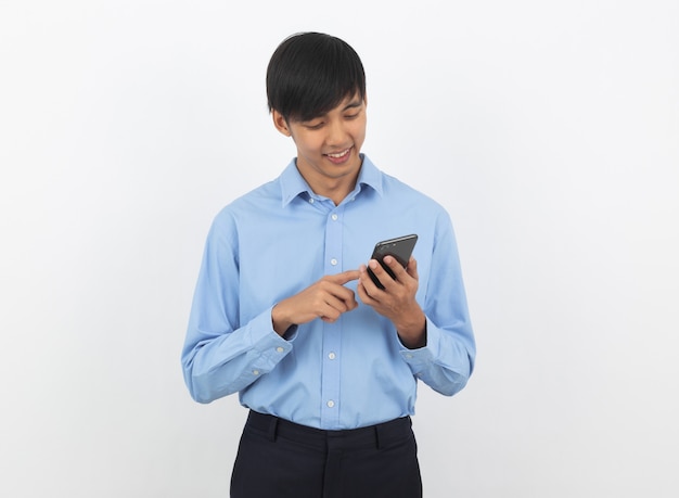 Hombre de negocios asiático hermoso joven que juega smartphone con sonrisa aislado en blanco