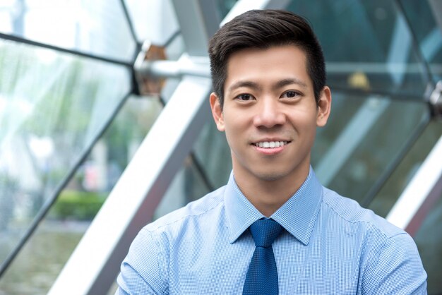 Hombre de negocios asiático hermoso sonriente joven en salón de la oficina