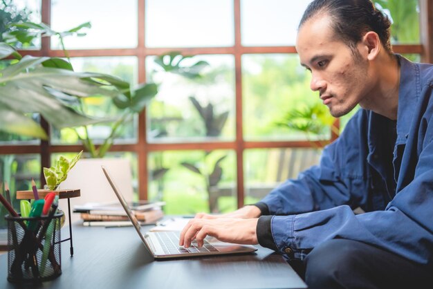 Hombre de negocios asiático persona empresario independiente que trabaja en un espacio de coworking o cafetería