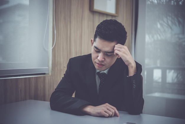 Un hombre de negocios asiático piensa en el trabajo en la oficina Un trabajador de Tailandia tiene ideas para un proyecto para el mañana