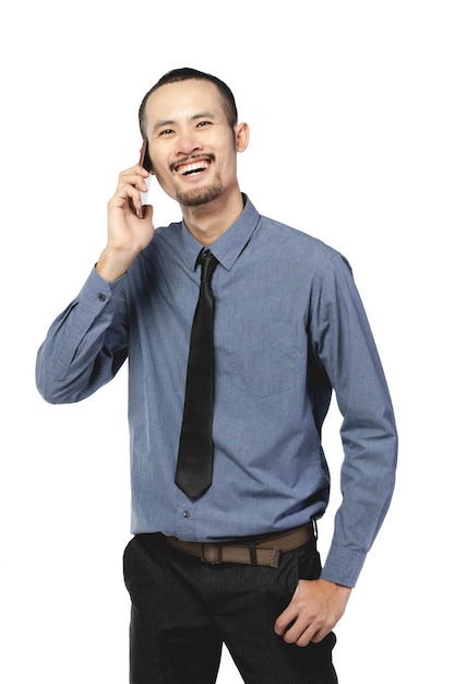 Hombre de negocios asiático que lleva usando el teléfono móvil sobre blanco.