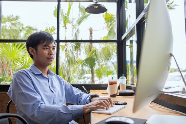 hombre de negocios asiático trabajando en la cafetería