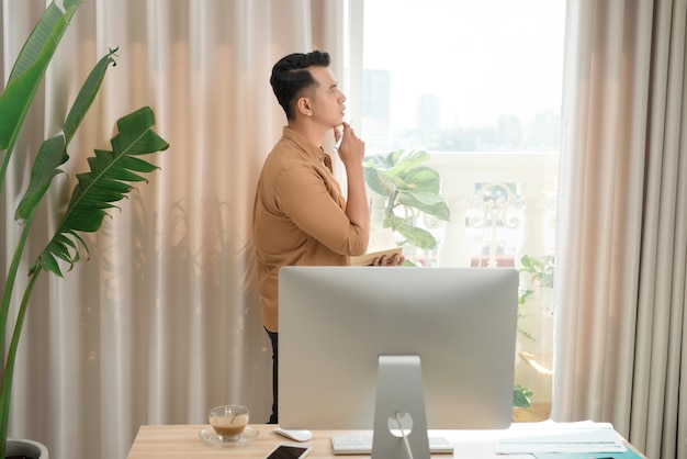 Hombre de negocios asiático trabajando en equipo portátil y pensando en el trabajo