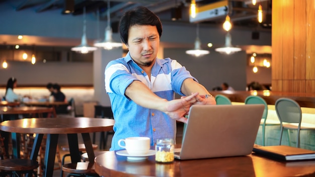 Hombre de negocios asiático en traje casual trabajando sufriendo de dolores y molestias