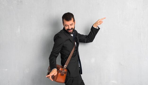 Un hombre de negocios con barba disfruta del baile mientras escucha música en una fiesta