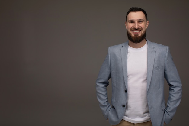 Hombre de negocios con barba guapo elegante aislado en gris.