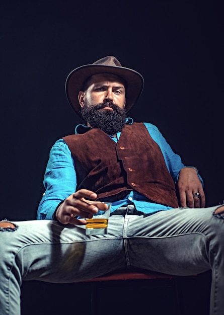 Hombre de negocios barbudo en traje elegante con vaso de whisky concepto de estilo de moda alegre hombre barbudo...