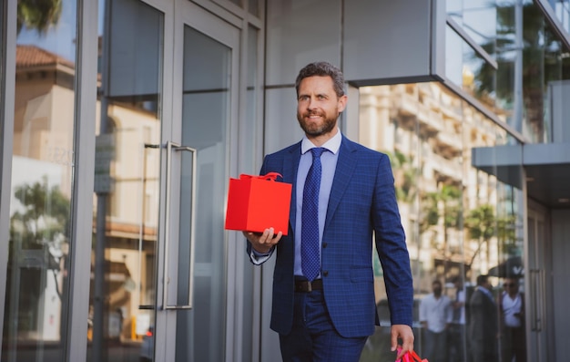 hombre de negocios, con, bolsa de compras, guapo, sonriente, confiado, hombre de negocios, retrato