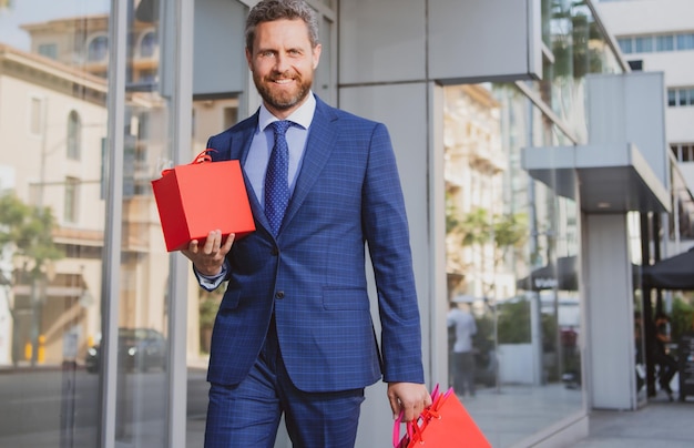 Hombre de negocios con bolsa de compras. Guapo sonriente retrato de hombre de negocios confiado.