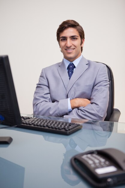 Foto hombre de negocios con los brazos cruzados apoyándose satisfecho