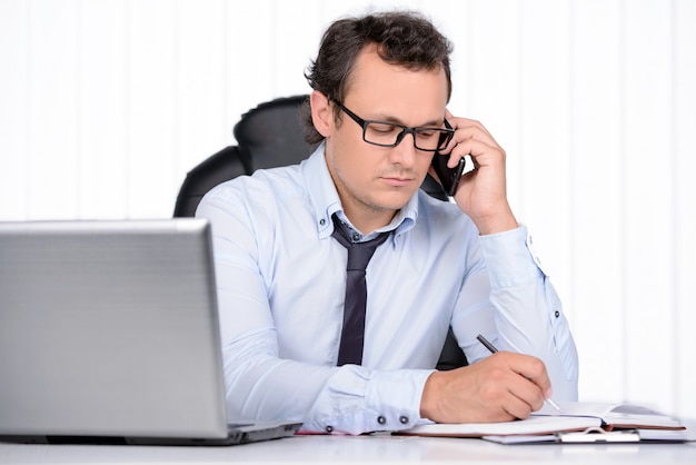 Hombre de negocios en camisa y corbata, trabajando en la oficina.