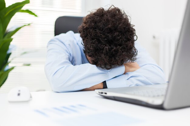 Hombre de negocios cansado durmiendo en su escritorio