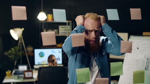 Foto un hombre de negocios cansado de un primer plano se pone nervioso por el proyecto en la oficina de hipster