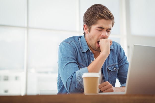 Hombre de negocios cansado sentado en el escritorio