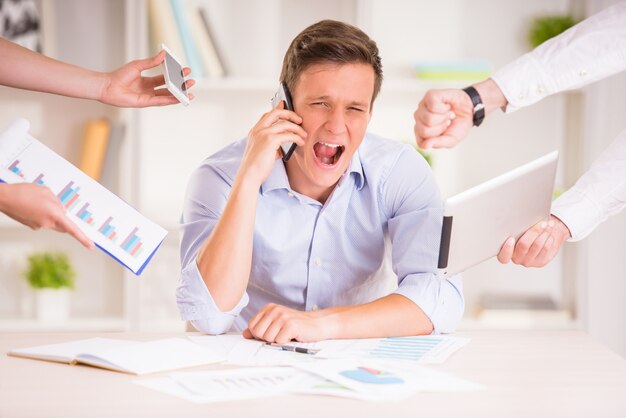 Hombre de negocios cansado en su oficina está gritando.