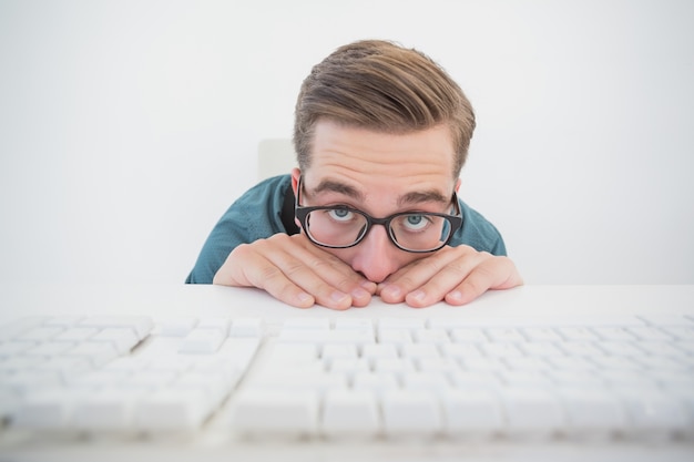 Hombre de negocios casual escondido en su escritorio