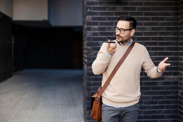 Un hombre de negocios casual hablando por teléfono afuera