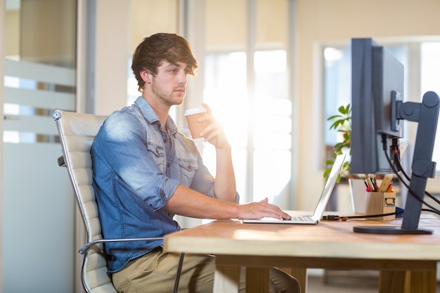 Hombre de negocios casual serio que se sienta en el escritorio